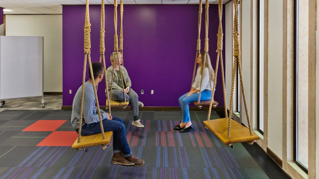 people sitting on swings in a room