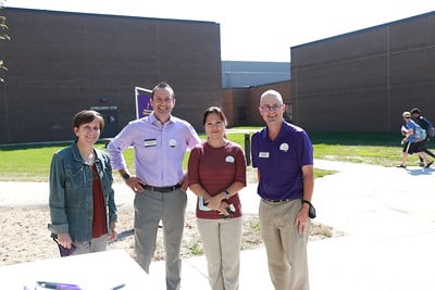 Four College of Business faculty members posing outside on campus