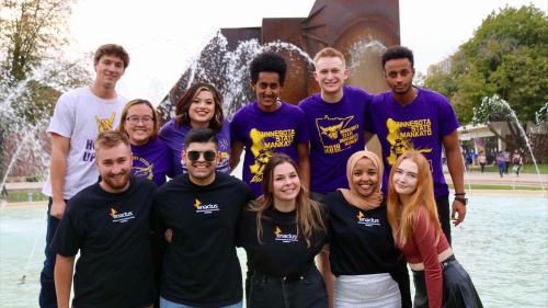 A group of students posing outside on campus in front of the fountain