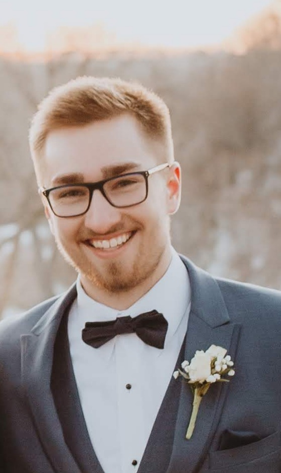 a person in a suit and glasses smiling