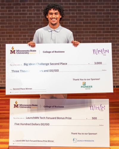 Akrem Ahmed posing with his Big Ideas Challenge awards