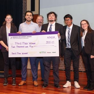 Bethany Lutheran College student winners posing for a group photo with a giant check at the 2023 FutureSolvers Challenge for 3rd place All C&S Farm award