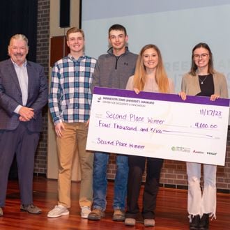 South Central College student winners posing for a group photo with a giant check at the 2023 FutureSolvers Challenge for 2nd place and AGCO mystery award
