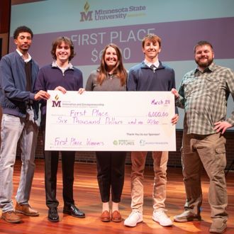 Minnesota State University, Mankato STEM Track and Tech-Forward student bonus prize winners posing for a group photo with a giant check at the 2025 FutureSolvers Cultivation Challenge for first place Hops Harvester
