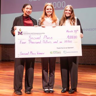 Gustavus Adolphus College Business Track student winners posing for a group photo with a giant check at the 2025 FutureSolvers Cultivation Challenge for second place ReVive Rural