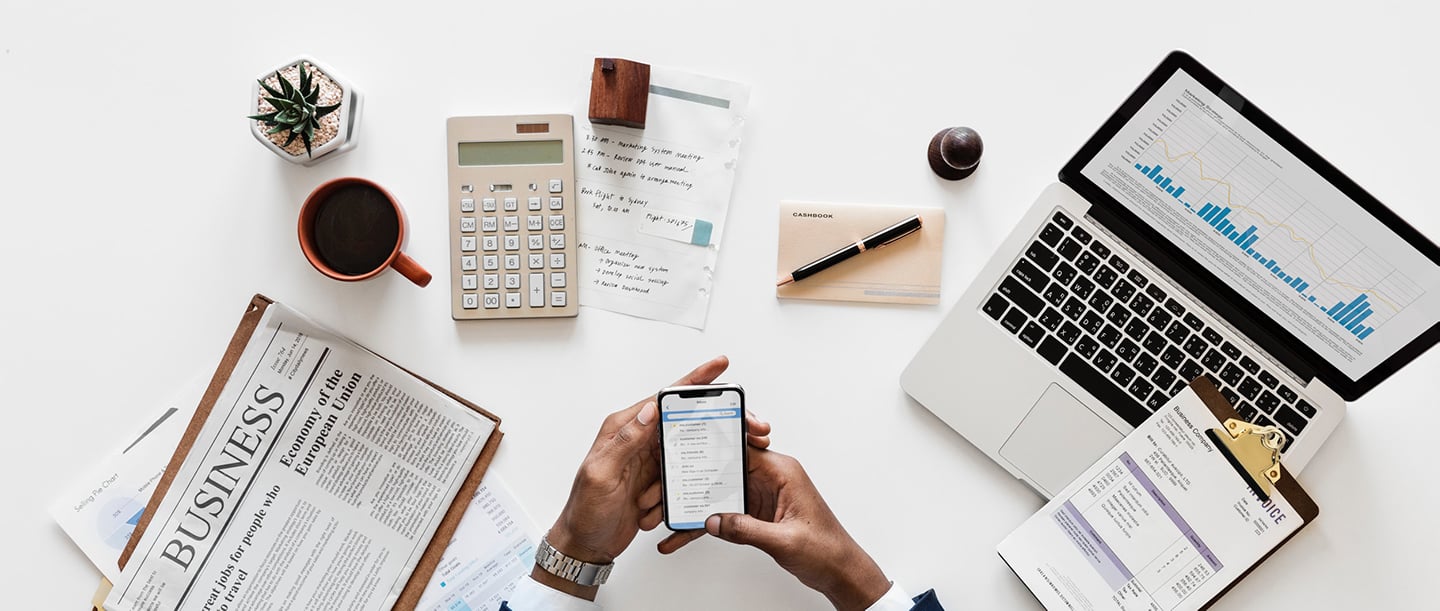 a person holding a phone and a calculator