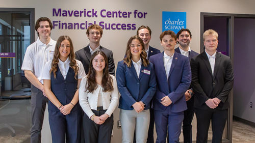 Students posing outside of the Charles Schwab Foundation Center for Financial Wellness center for the ribbon cutting ceremony