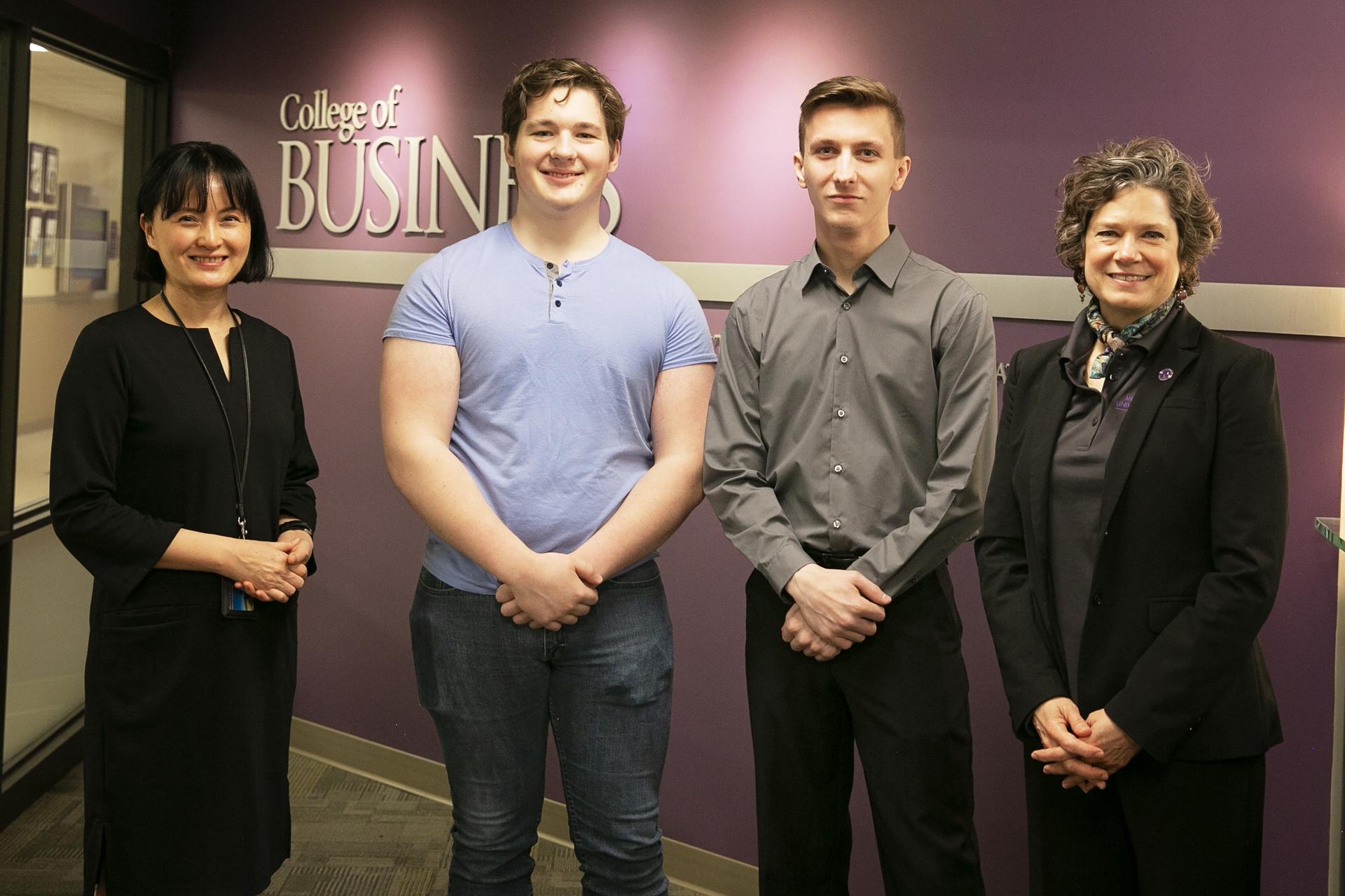 a group of people standing in front of a purple wall