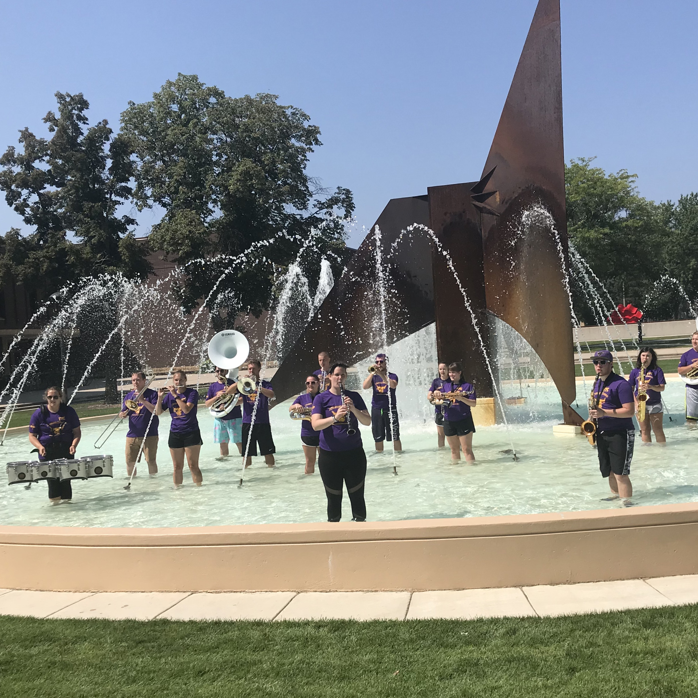 a group of people playing instruments in a fountain