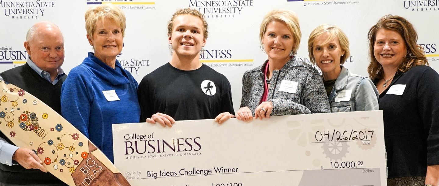 The 2017 Big Ideas Challenge winners, Primate Longboards, posing with the giant check they won from the College of Business