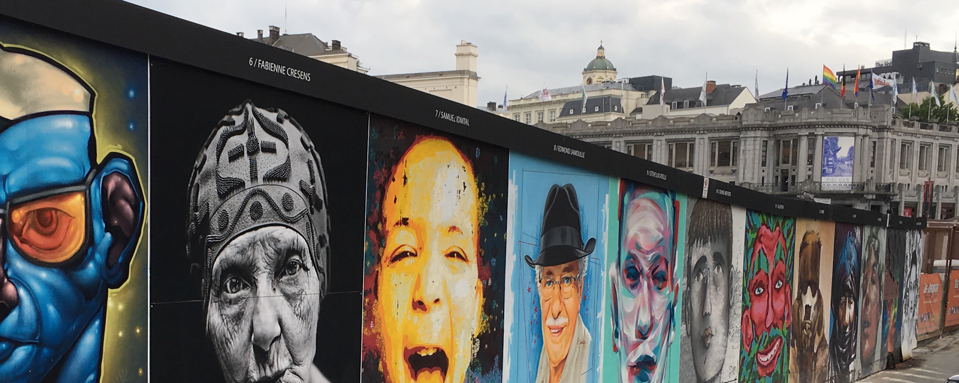 Street art in Rue Ravenstein, Brussels, Belgium of 40 portraits by 40 artists on temporary walls around building works