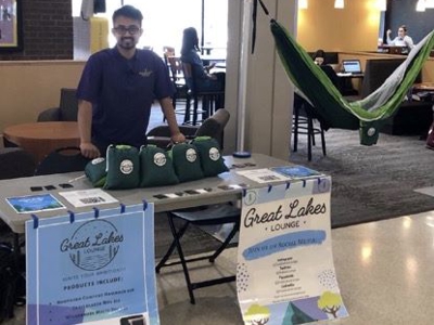 A student selling Northern Comfort hammocks, Trailblazer mugs and Wilderness Multi-too for the Spring 2019 Great Lakes Lounge student project