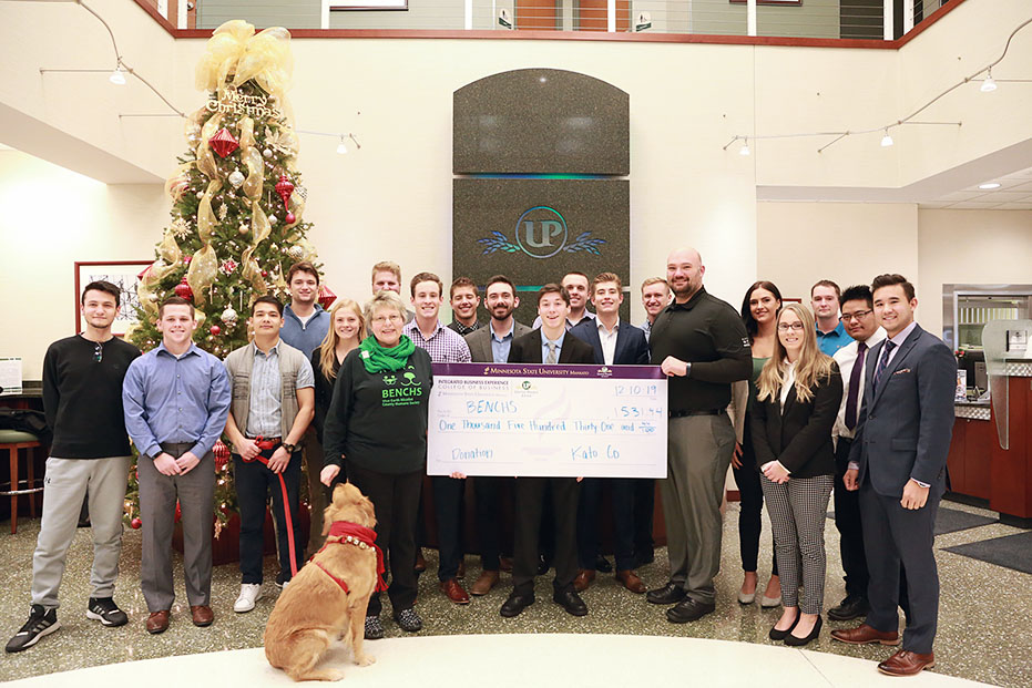 a group of people posing for a photo with a large check